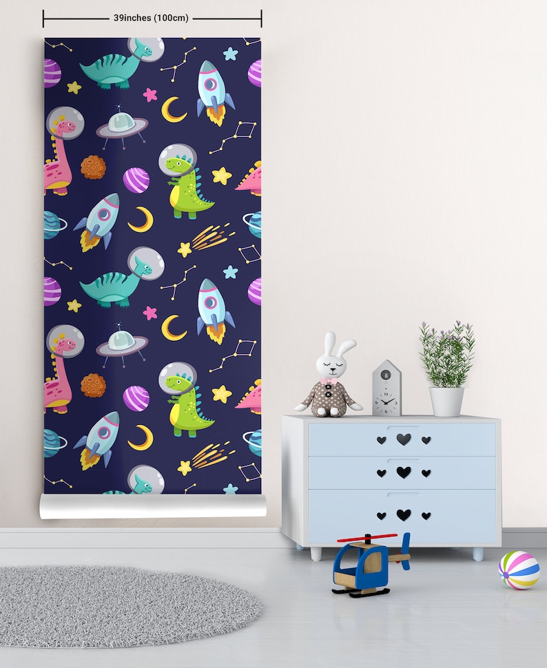 May include: A 39-inch (100 cm) wallpaper roll with a repeating pattern of dinosaurs wearing astronaut helmets, spaceships, planets, stars, and comets on a dark blue background.