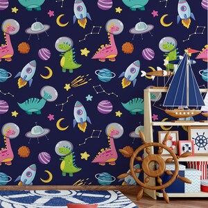 May include: A dark blue wallpaper with a repeating pattern of dinosaurs wearing astronaut helmets, rockets, stars, planets, and moons. The wallpaper is in a room with a wooden shelf and a wooden ship's wheel.
