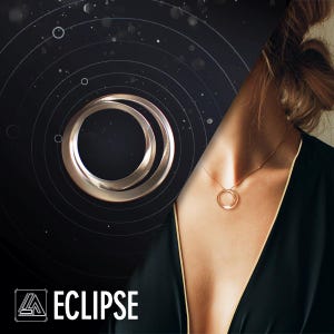 Puede incluir: Un collar dorado con dos círculos entrelazados se usa con una blusa negra. La imagen está dividida diagonalmente, con un gráfico de círculos concéntricos y la palabra "ECLIPSE" en la esquina inferior izquierda.