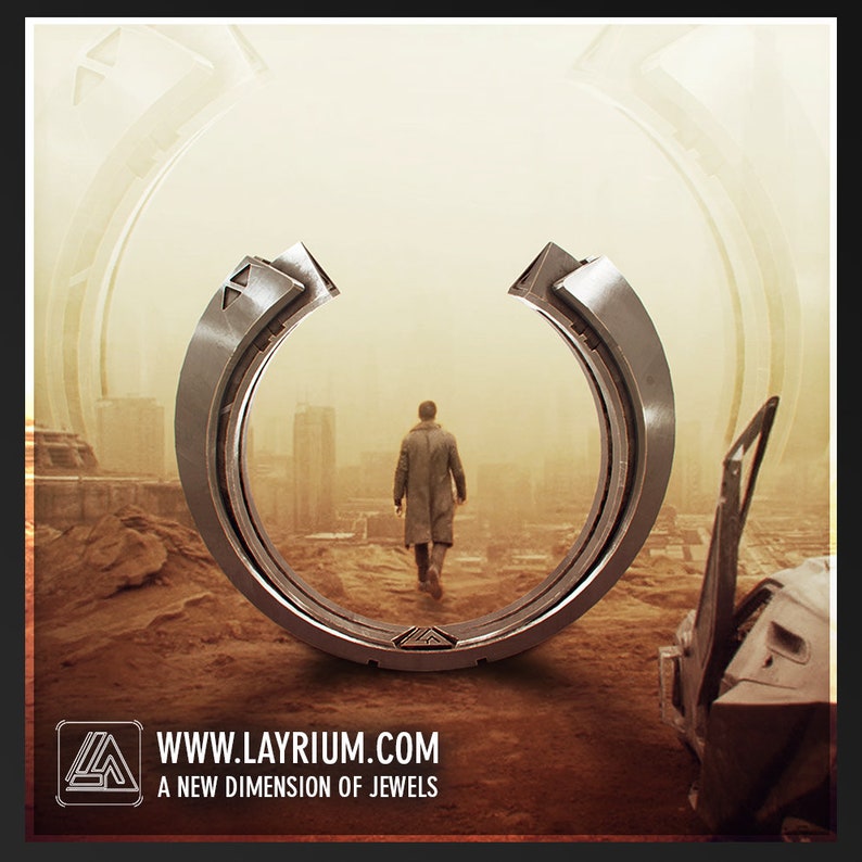 May include: A silver-colored ring with a futuristic design, featuring geometric shapes and a circular form. The ring is set against a dystopian landscape with a person walking away. The website address www.layrium.com and the tagline "A new dimension of jewels" are also visible.