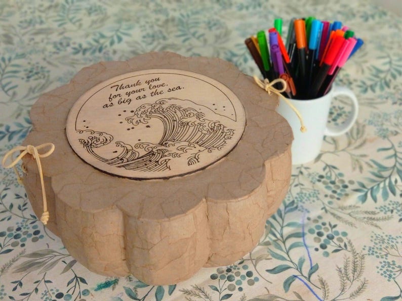Personalized biodegradable sea burial urn with a heartfelt engraved message on the wooden lid, created for a meaningful farewell