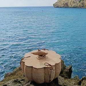 Close-up of a dolphin sea life symbol applied to the wooden lid of the SOUL SEA biodegradable water burial urn