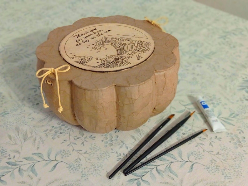Handmade biodegradable urn that can be personalized with natural paint or dyes to create a unique memorial design