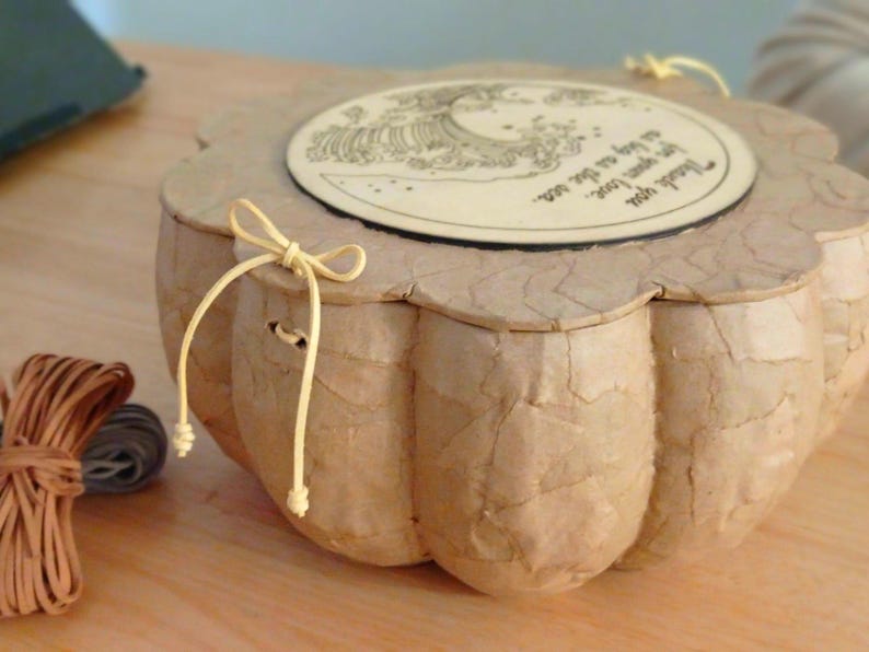 Close-up of the BLUE SOUL urn wooden lid secured with natural cotton cords and leather fastening details