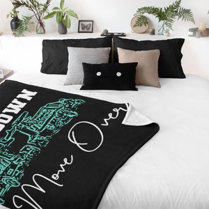 Puede incluir: Manta de tiro negra y blanca con un gráfico verde turquesa de una línea de vehículos todoterreno y el texto "Move Over" y "Get Down".