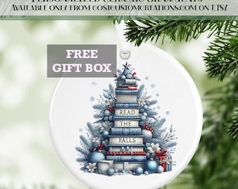 May include: A white ceramic bauble shaped like a Christmas tree made of stacked books. The books have blue covers and the top book reads "Read the Halls". The bauble is decorated with blue and white baubles and a red bow.