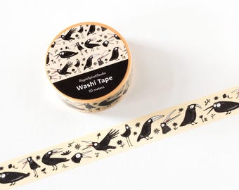 May include: A roll of washi tape with a black and white bird pattern. The tape is unrolled, revealing a repeating design of stylized birds and floral elements. The text "Washi Tape 10 meters" is visible on the roll.