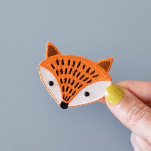 May include: Orange felt fox head applique with black embroidered eyes and nose.