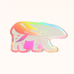 May include: A holographic sticker featuring a polar bear with a whale and fish swimming around it. The sticker says "Save Us" in the top right corner.