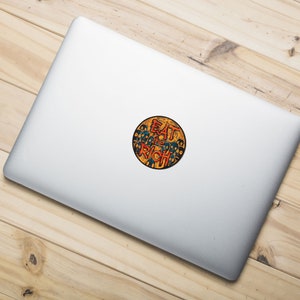 May include: A round sticker with a yellow background and a black outline. The sticker features a graphic of a crowd of people with their faces obscured by black circles. The text "EAT THE RICH" is written in red and orange letters.