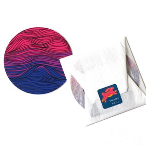 May include: A white envelope with a blue and pink striped circle sticker and a blue sticker with a red rabbit and the text "Thank You!"