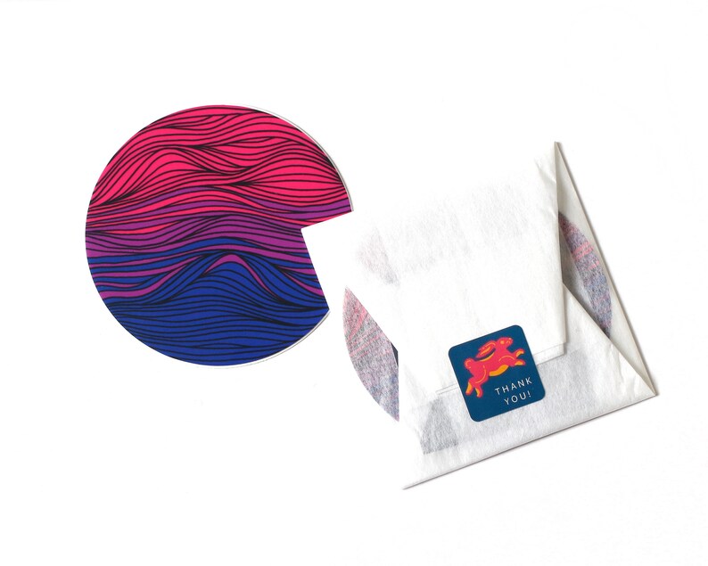 May include: A white envelope with a blue and pink striped circle sticker and a blue sticker with a red rabbit and the text "Thank You!"