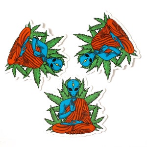 May include: Three blue alien figures in a meditative pose, wearing orange robes and surrounded by green marijuana leaves. The aliens have large eyes and are sitting in a lotus position.