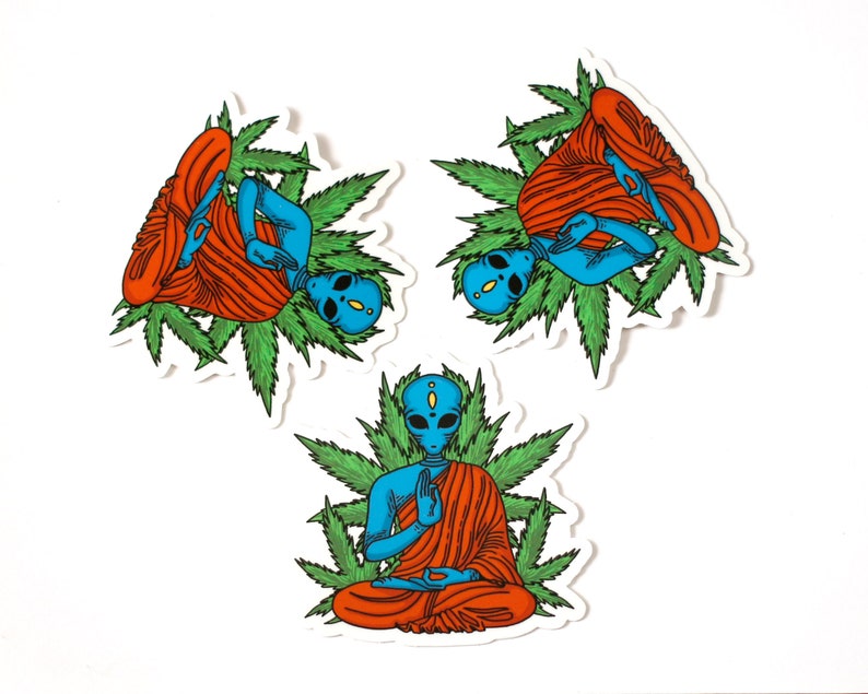 May include: Three blue alien figures in a meditative pose, wearing orange robes and surrounded by green marijuana leaves. The aliens have large eyes and are sitting in a lotus position.