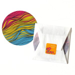 May include: A round sticker with a colorful wavy pattern in pink, yellow, and blue. The sticker is on a white background. A smaller sticker with a snake design and the text "Thank You!" is also visible.