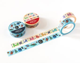 May include: Several rolls of washi tape with colorful cat and space-themed designs. The tape features illustrations of cats in spacesuits, planets, and the text "Give Me Space". The rolls are in various colors, including blue, beige, and red.