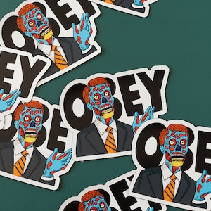 May include: Multiple stickers featuring a blue and red alien character with the word "OBEY" in black text.