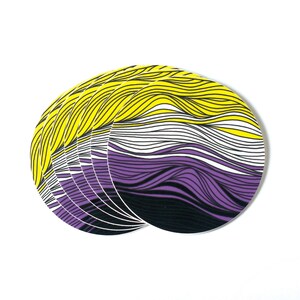 May include: A stack of round stickers with a yellow, white, and purple striped design. The stripes are wavy and resemble a flowing pattern.