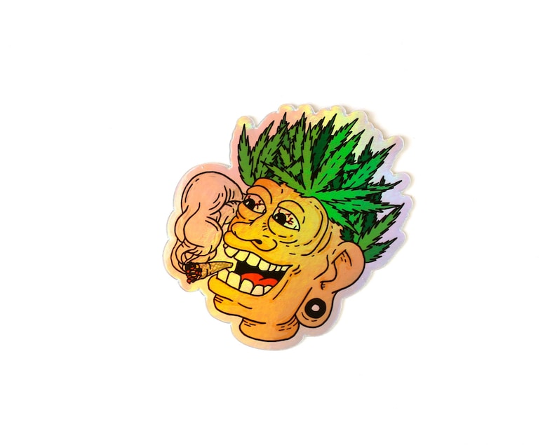 Peut inclure: Autocollant holographique repr&eacute;sentant un visage de dessin anim&eacute; avec des feuilles de cannabis vertes en guise de cheveux, un joint allum&eacute; et un large sourire. Le visage est jaune et orange avec une boucle d'oreille noire. De la fum&eacute;e s'&eacute;chappe du joint.