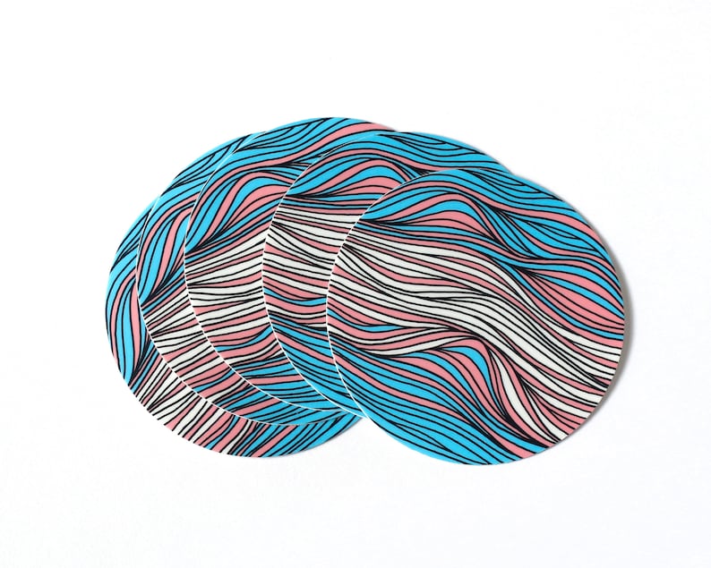 May include: Four round coasters with a wavy pattern in blue, pink, and white. The coasters are stacked on top of each other.
