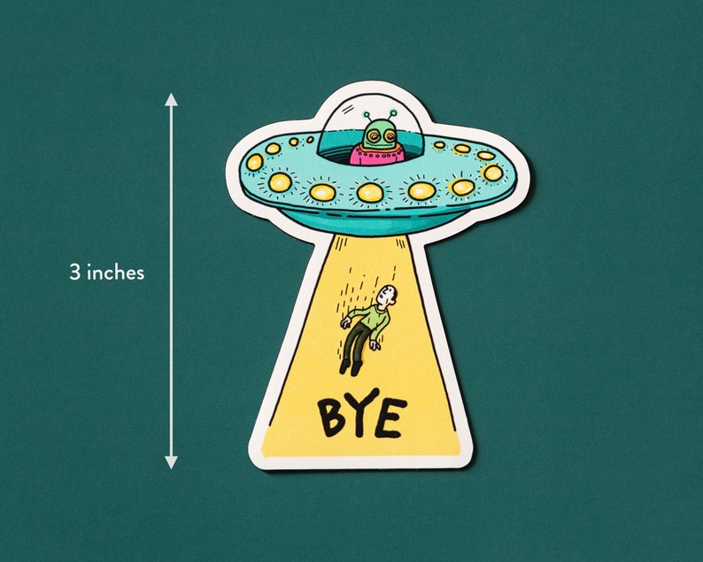 May include: A yellow and blue cartoon UFO with a green alien inside is beaming a person up with the word "BYE" written on the beam. The UFO is 3 inches tall.