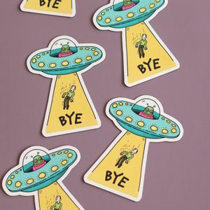 May include: Five colorful stickers with cartoon illustrations of spaceships and aliens. Each sticker has the word "BYE" printed on it.
