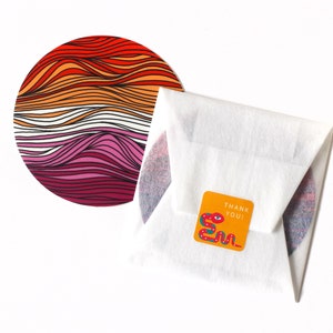 May include: A round sticker with a colorful design of wavy lines in red, orange, pink, and white. The sticker is packaged in a white envelope with a small orange sticker that says "Thank You!" and features a red, green, and blue snake design.
