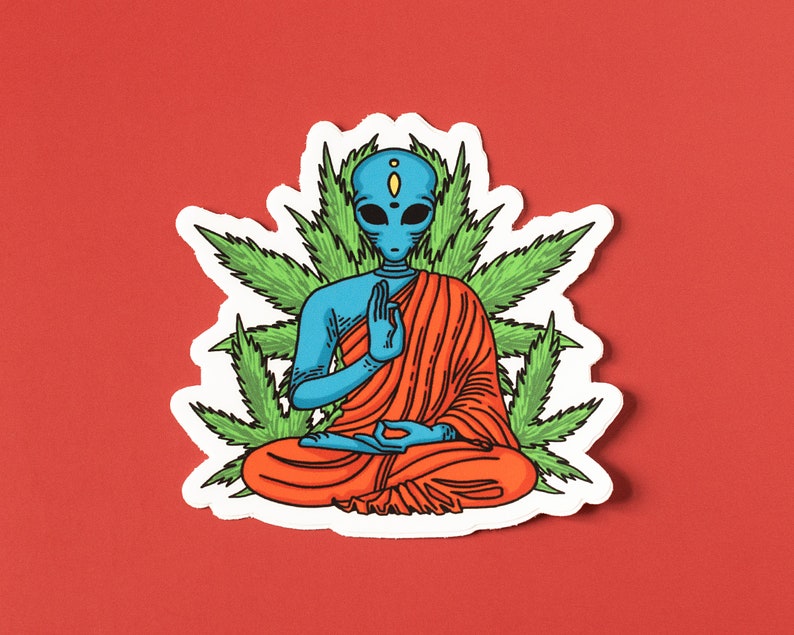 May include: A blue alien meditating in a red robe, surrounded by green marijuana leaves. The alien has a third eye and is in a peaceful pose.