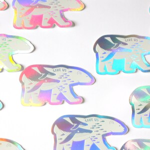 May include: A set of nine iridescent holographic stickers featuring a polar bear with a whale and fish swimming inside of it. The stickers have the text "Save Us" printed on them.