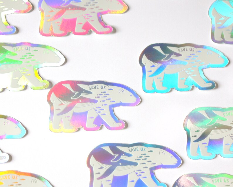 May include: A set of nine iridescent holographic stickers featuring a polar bear with a whale and fish swimming inside of it. The stickers have the text "Save Us" printed on them.