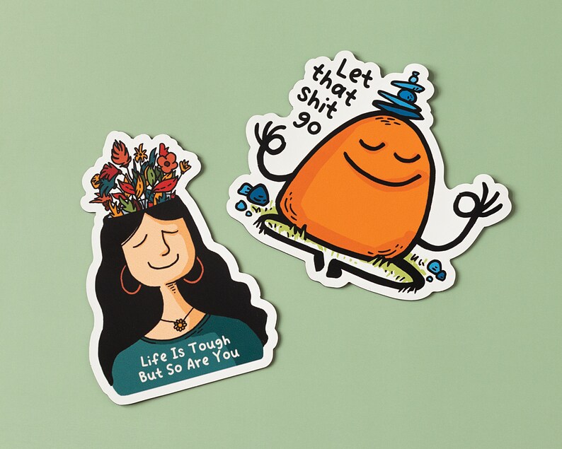 May include: Two colorful stickers with motivational messages. One sticker features a cartoon person with flowers growing out of their head and the text "Life is tough but so are you". The other sticker features a cartoon orange character meditating with the text "Let that shit go".