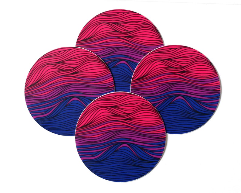 May include: Set of four round coasters with a wavy pattern in shades of pink, purple, and blue.