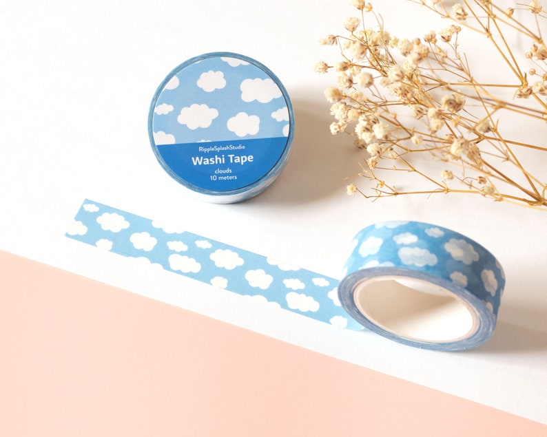 May include: Two rolls of washi tape with a blue sky and white cloud pattern. One roll is unrolled, showing the pattern. The text on the roll reads "RippleSplashStudio Washi Tape clouds 10 meters."