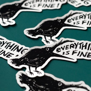 May include: Four black and white stickers with a crow illustration and the text "Everything is fine!" printed on them. The stickers are on a teal surface.