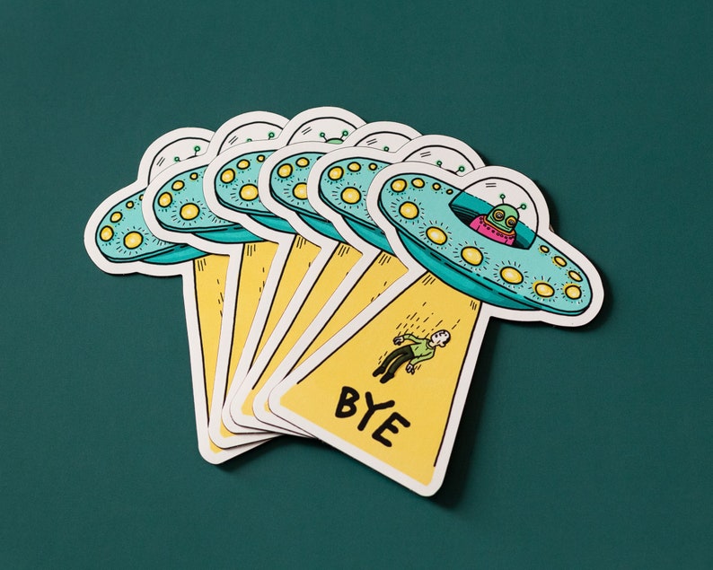 May include: A set of six colorful stickers featuring a cartoon alien in a flying saucer with the text "BYE" on a yellow background.