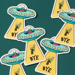 May include: A set of six yellow and green alien-themed stickers with the word "BYE" on each. The stickers feature cartoon aliens in flying saucers with people falling from the saucers.