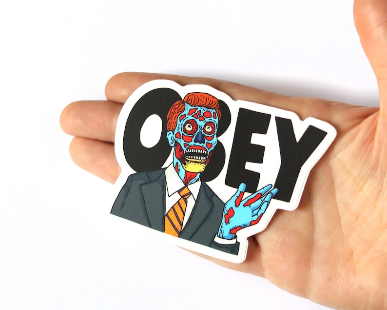May include: A sticker featuring a cartoon character with a red and blue face, wearing a suit and tie, with the word "OBEY" in black letters.