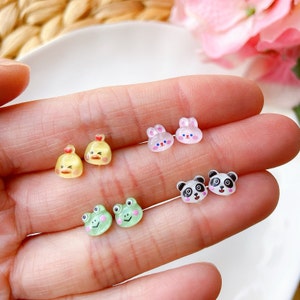 May include: A set of six colorful animal-shaped earrings. The earrings are made of resin and feature a chick, a frog, a panda, and two bunnies. The earrings are small and delicate, perfect for adding a touch of whimsy to any outfit.