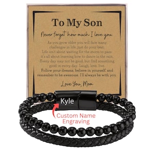 May include: A black leather and beaded bracelet with a magnetic clasp. The bracelet is personalized with the name "Kyle" and the words "Custom Name Engraving". A card behind the bracelet reads "To My Son" with a heartfelt message.