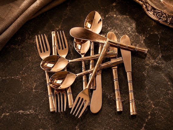 Full handcrafted solid copper flatware set — the warm reddish-gold tone makes every table setting look like a moody editorial shoot.
