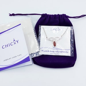 K&ouml;nnte beinhalten: Eine Halskette aus Sterlingsilber mit einem marquise-geschliffenen rotbraunen Steinanh&auml;nger, verpackt in einer transparenten Kunststoffh&uuml;lle mit CHICXY-Markenkarte. Enth&auml;lt einen violetten Samtbeutel und ein Schmuckpflegeheft.