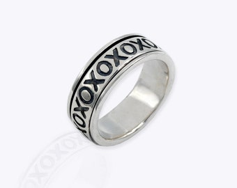May include: A silver ring with a black band and the word "XOXO" engraved around it.