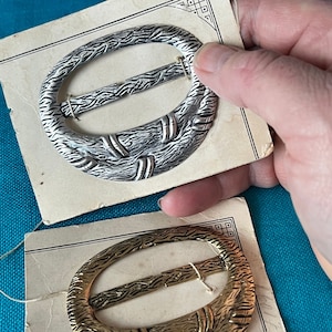 Fivelas de cinto deslizantes Art Déco em metal dourado e prateado. Ambos sem pontas. Provavelmente década de 1930. Fixado em cartolinas velhas.