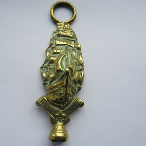 May include: A brass doorstop shaped like a ship with a crest that reads "C.P.S.A."