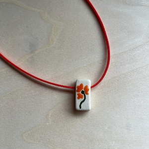 Ceramic orange flower bead necklace with faux suede cord