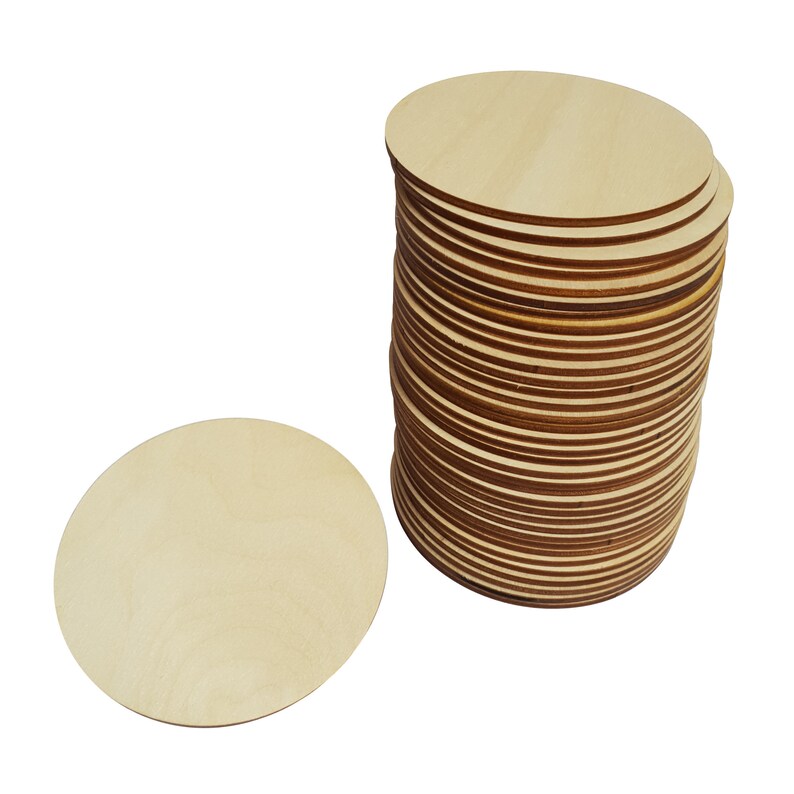 May include: A stack of round, unfinished wooden craft circles. The circles are approximately 3 inches in diameter and are made of light-colored wood.