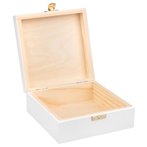 Pu&ograve; includere: Una scatola di legno bianca con un coperchio incernierato e una chiusura dorata. La scatola &egrave; aperta e l'interno &egrave; vuoto.