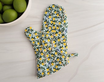 May include: A light blue oven mitt with a lemon and bird print. The mitt has a hanging loop.