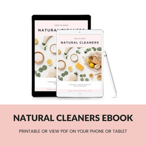May include: Two tablets displaying an ebook titled "How to Make Natural Cleaners." The ebook cover features natural cleaning ingredients. A white stylus rests beside the tablets. The text "Natural Cleaners Ebook" is below the tablets.