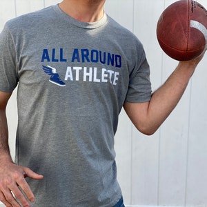 May include: A gray heather t-shirt with a blue and white graphic of a winged running shoe and the text "ALL AROUND ATHLETE".